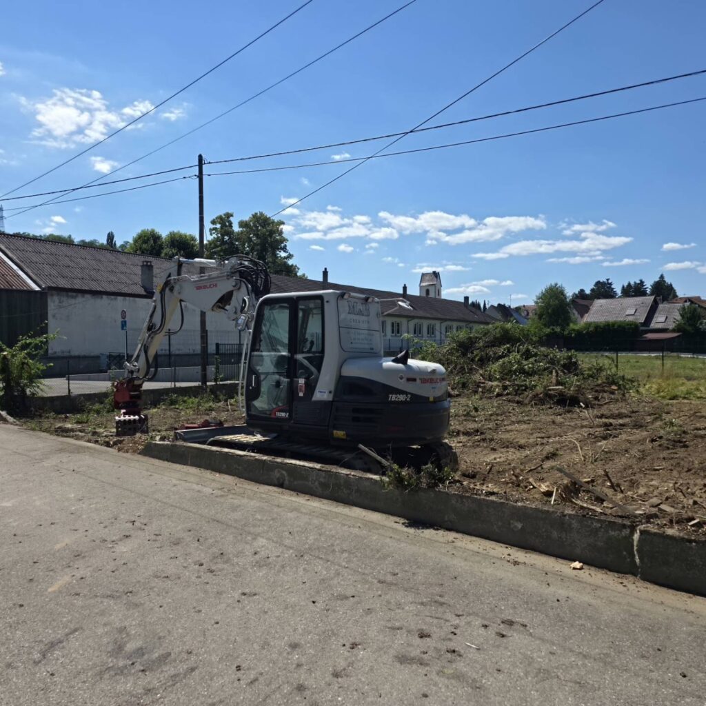 Terrain défriché et pelle en cours de terrassement