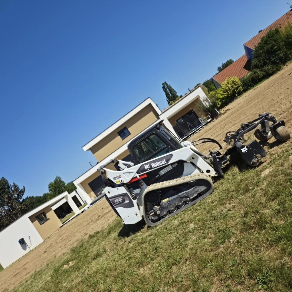 Bobcat T66 équipé du râteau motorisé sur le terrain